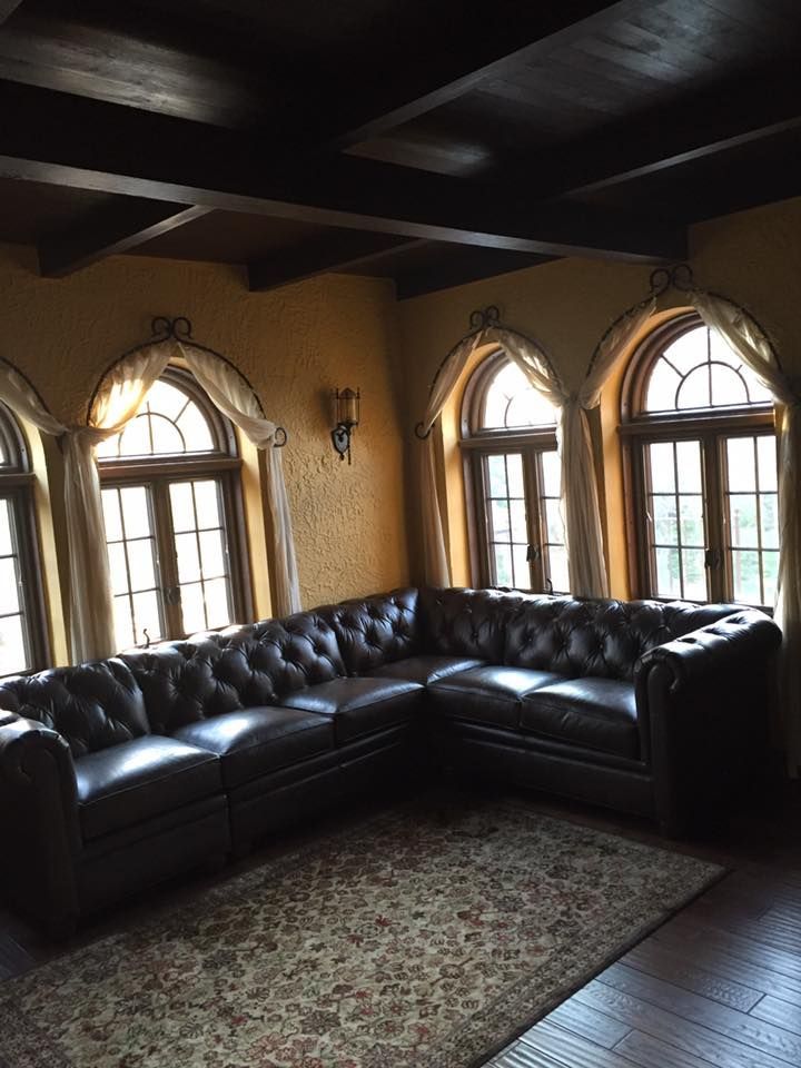 A Living Room With A Large Sectional Couch And Lots Of Windows