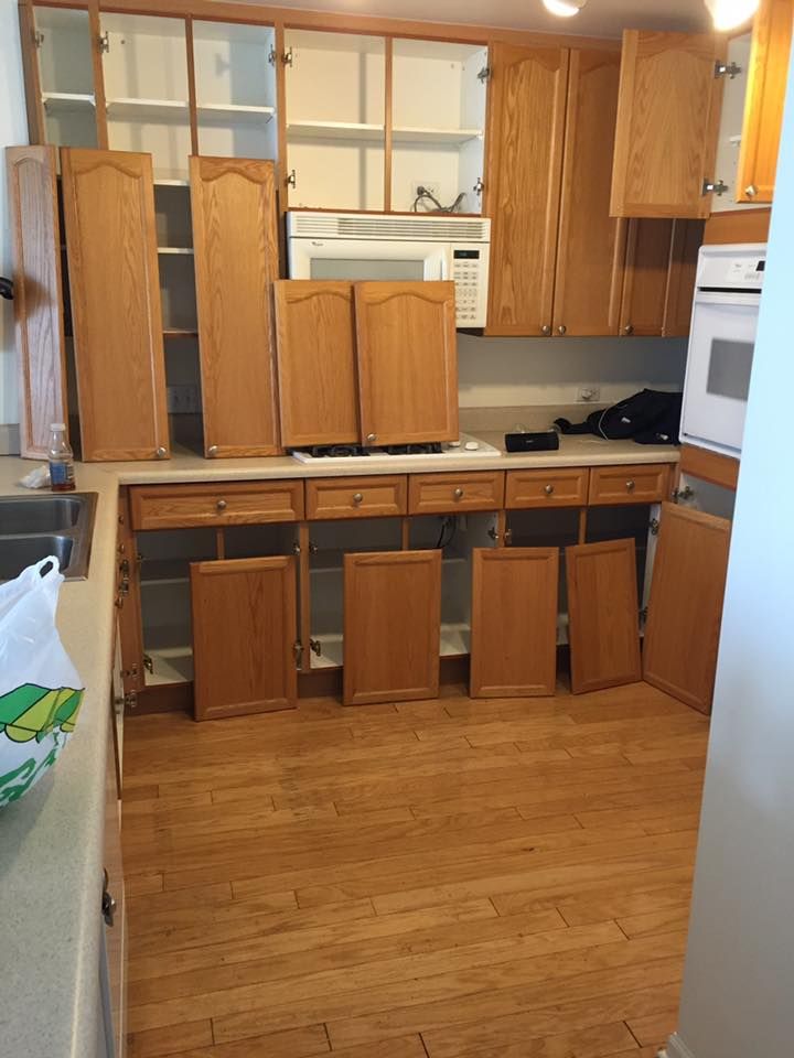 A Kitchen With Wooden Cabinets And A Microwave