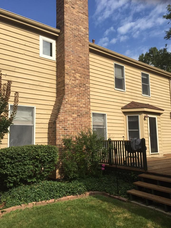 The Back Of A House With A Brick Chimney