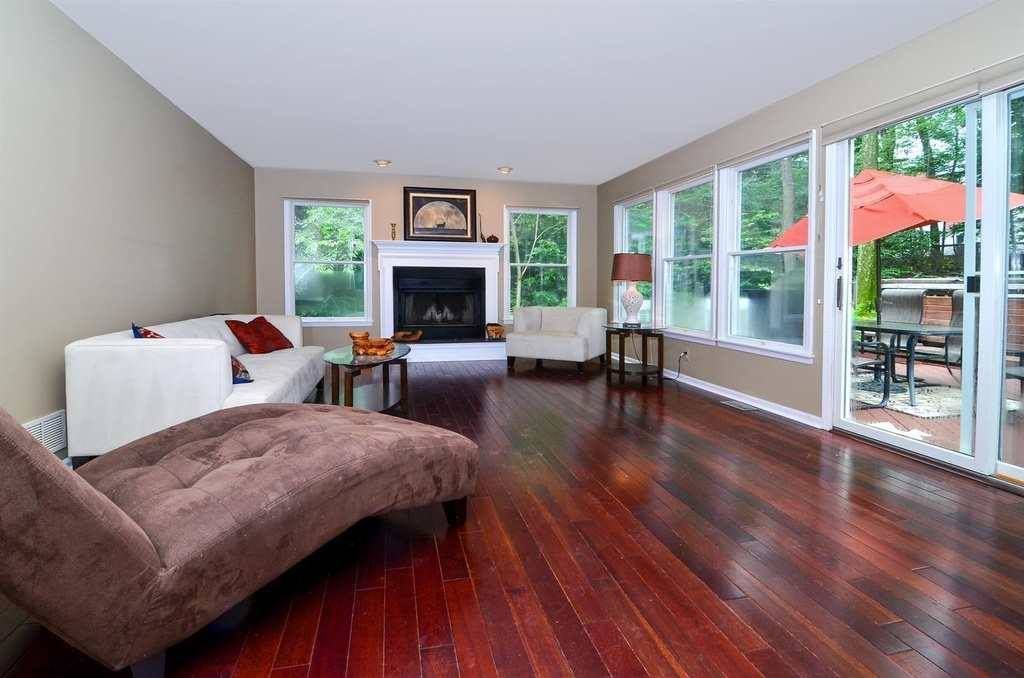 A Living Room With Hardwood Floors , A Couch And A Fireplace