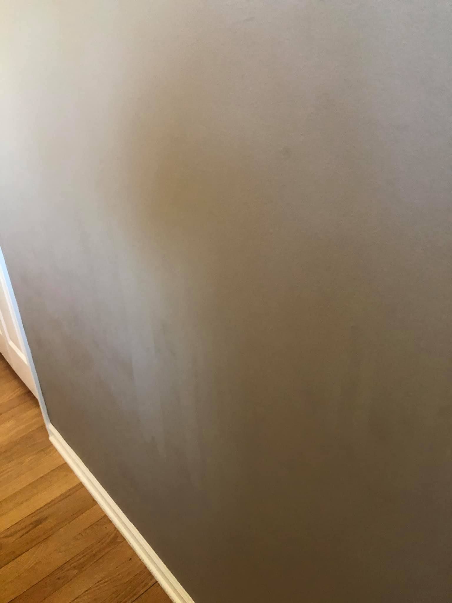A close up of a wall with a wooden floor in a room.