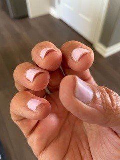 A close up of a person 's hand with pink nails.