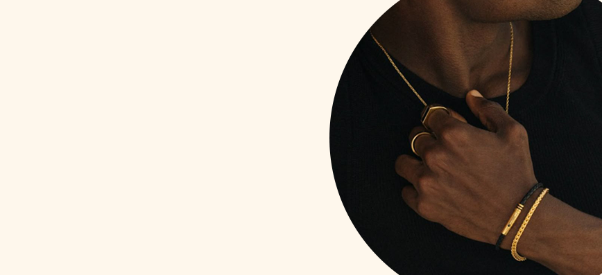 Un primer plano de una persona que lleva un collar y una pulsera.