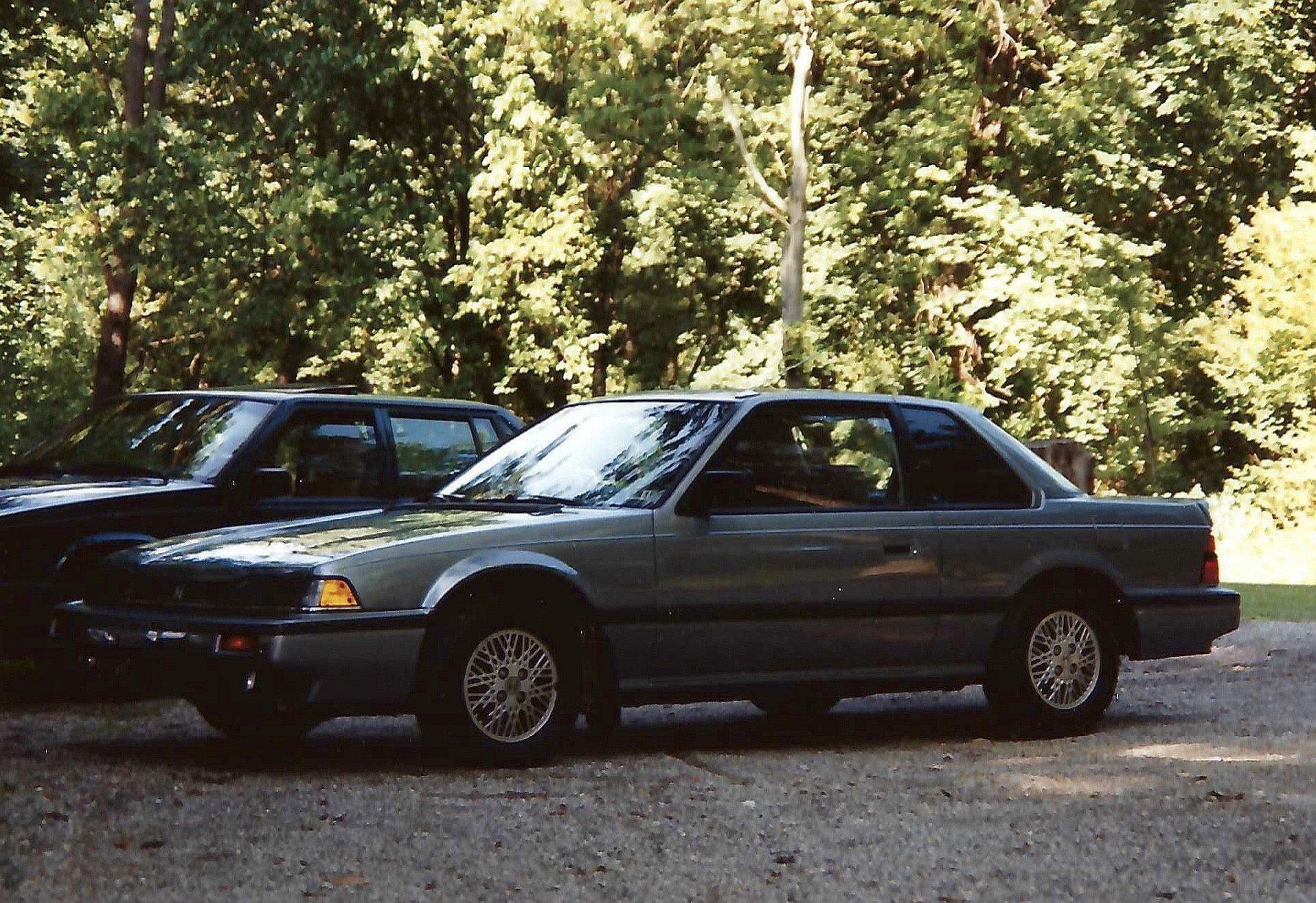 A silver car is parked next to a black car