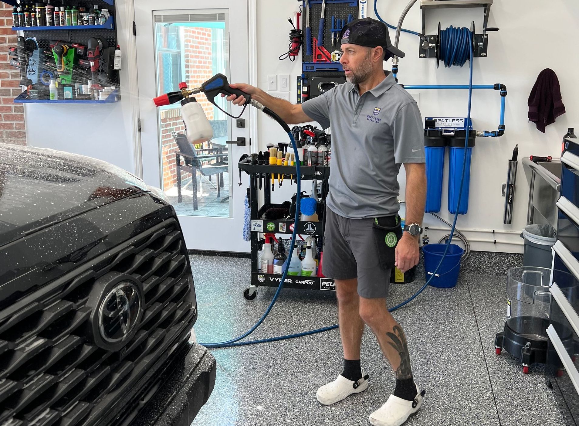 A man is washing a toyota truck in a garage.