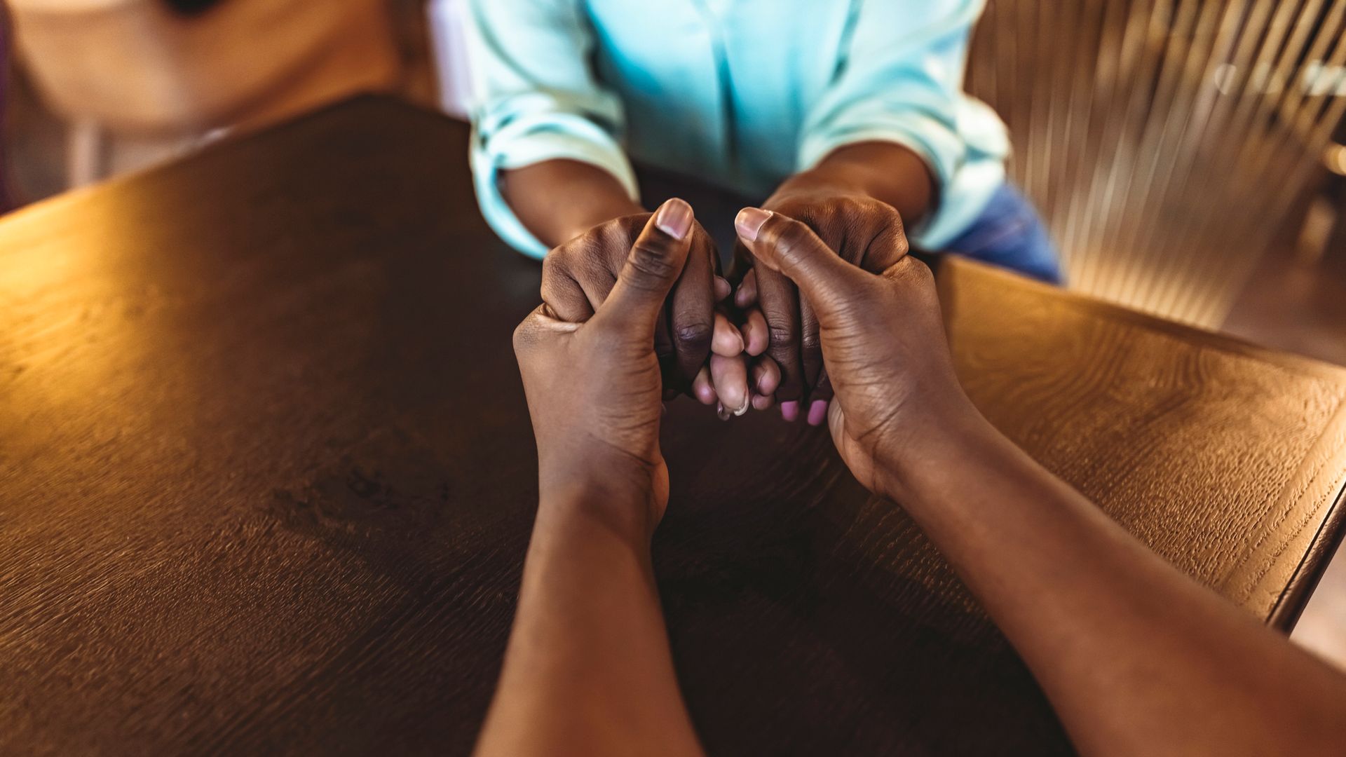 A couple of people are sitting at a table holding hands. - Lancaster, TX - International Harvest Fellowship Ministries