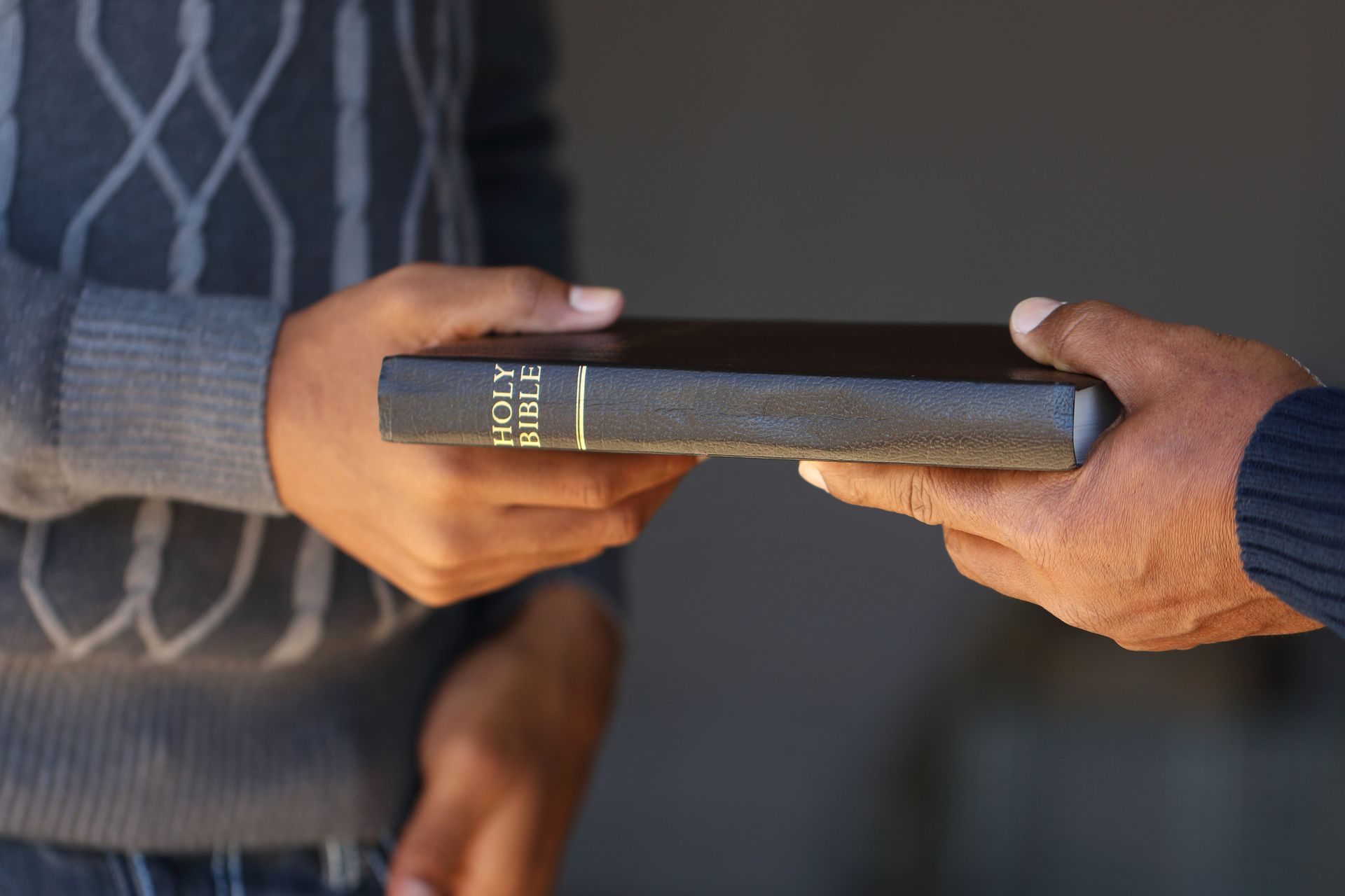 A man is handing a bible to another man. Lancaster, TX - International Harvest Fellowship Ministries