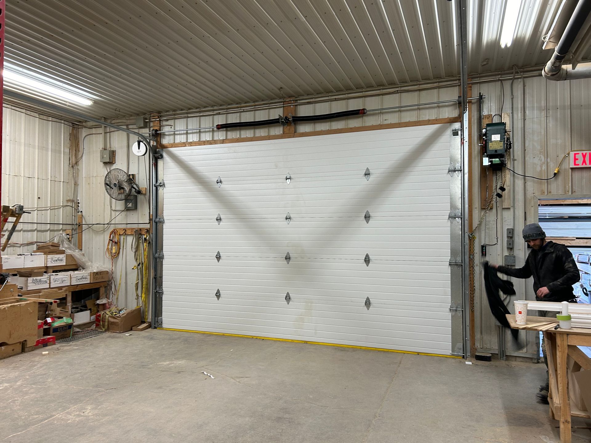 man opening a garage door in a building.