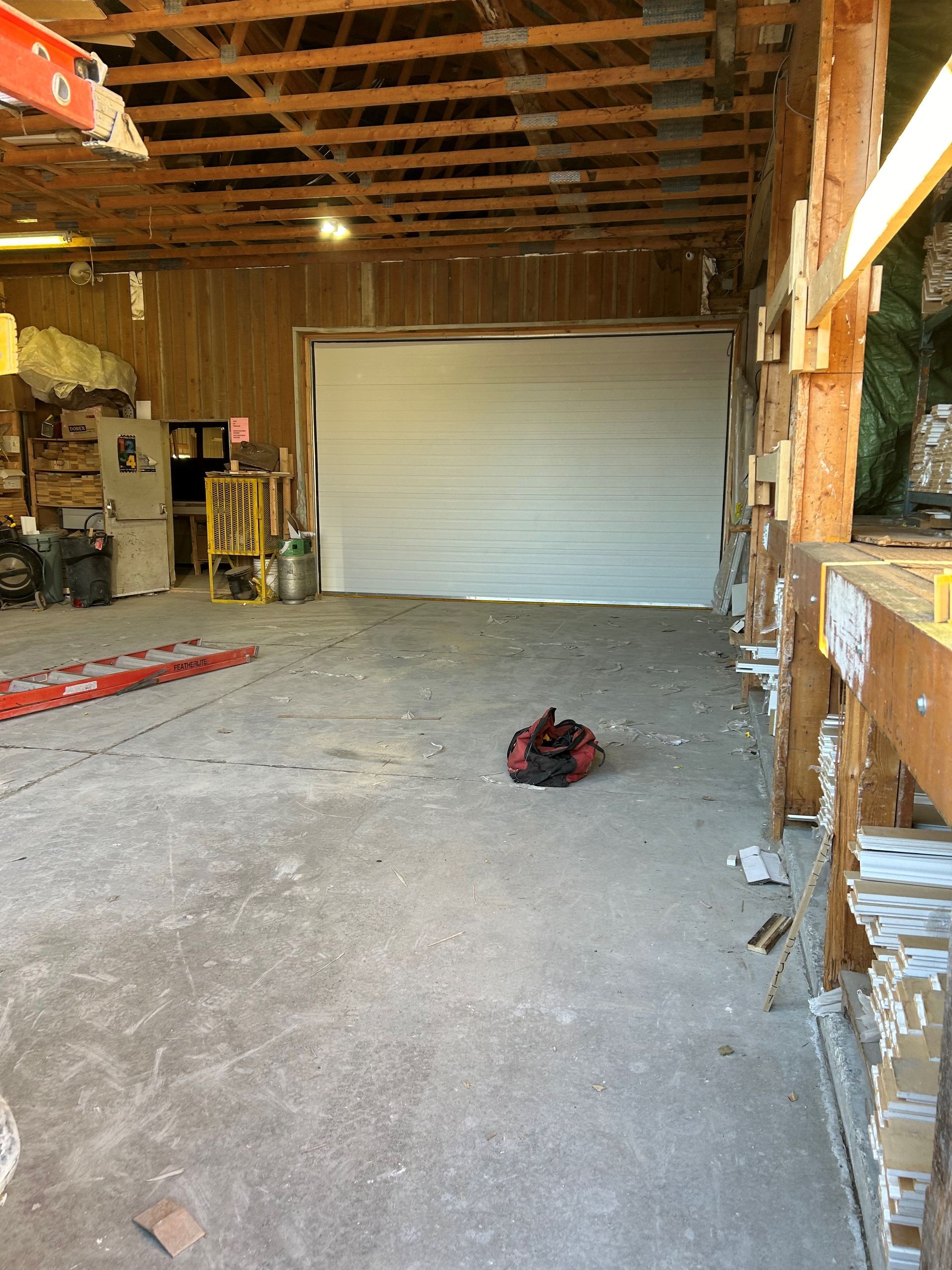 a white garage door and a red bag on the floor.
