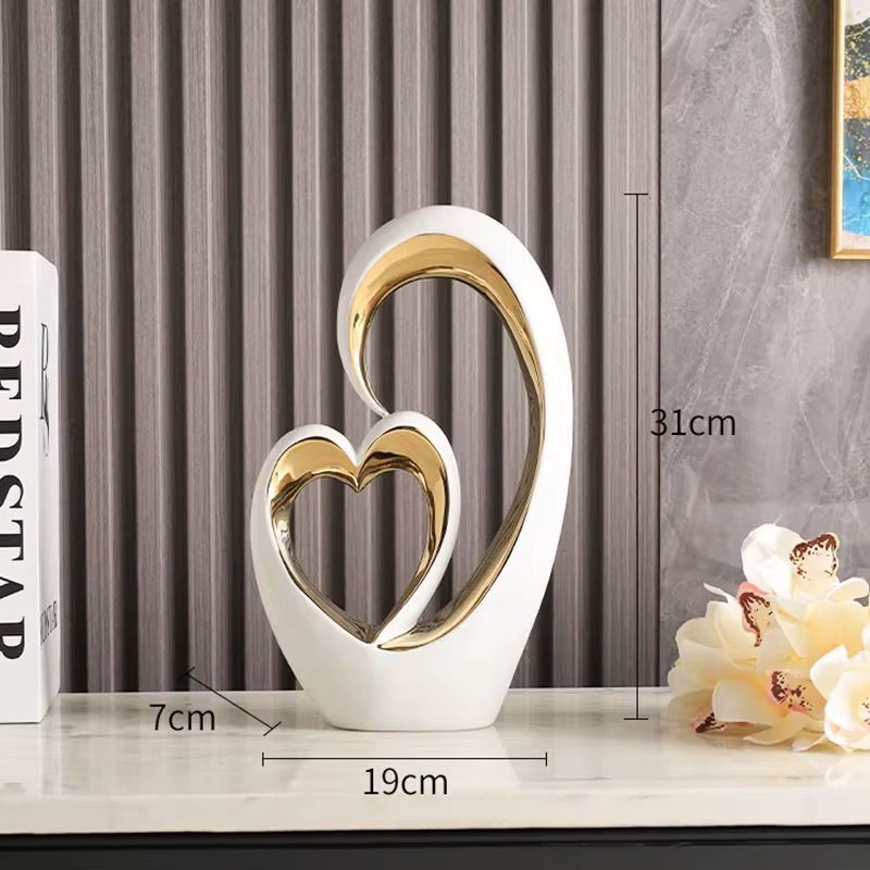 White and gold heart-shaped tabletop sculpture on a shelf with measurement labels