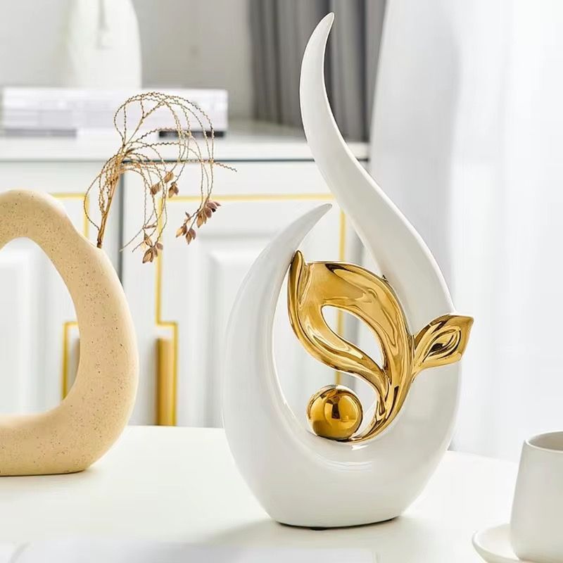 White and gold abstract floral sculpture with a smooth curved base on a white background
