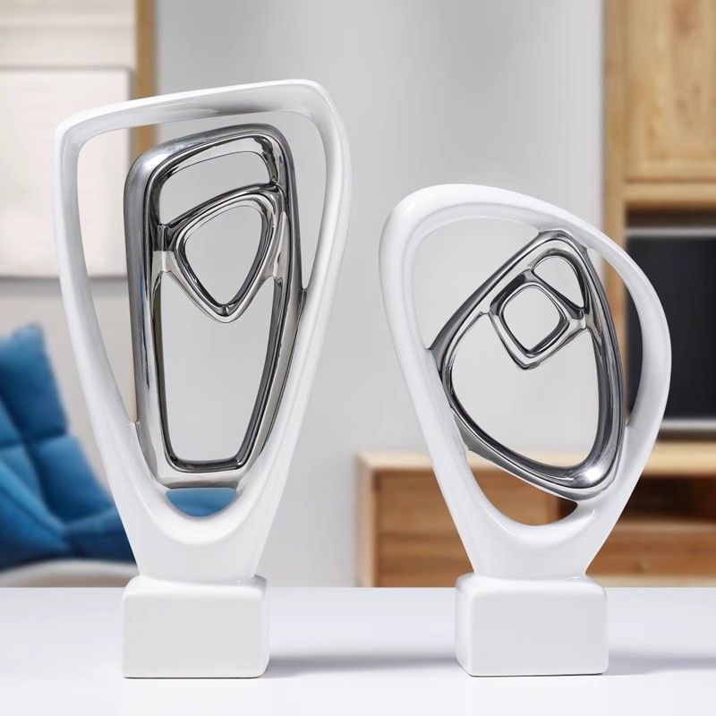 Abstract white and chrome trophy sculptures on a shelf