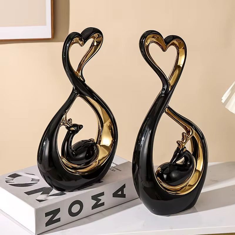 Set of two gold deer-shaped decorative figurines with heart tops, shown with size measurements.