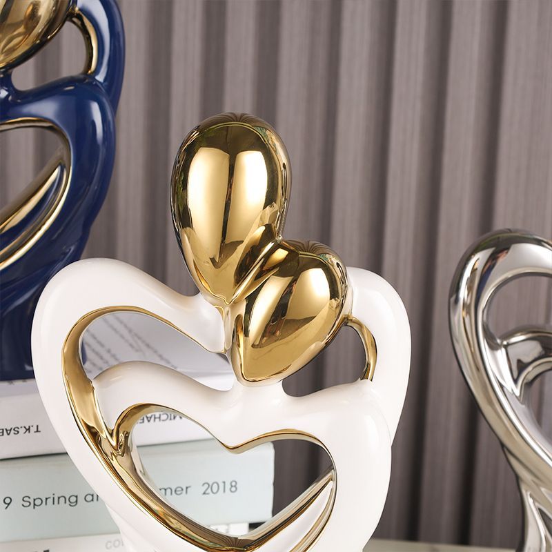 Gold and white heart-shaped trophies on a shelf with a gray striped background