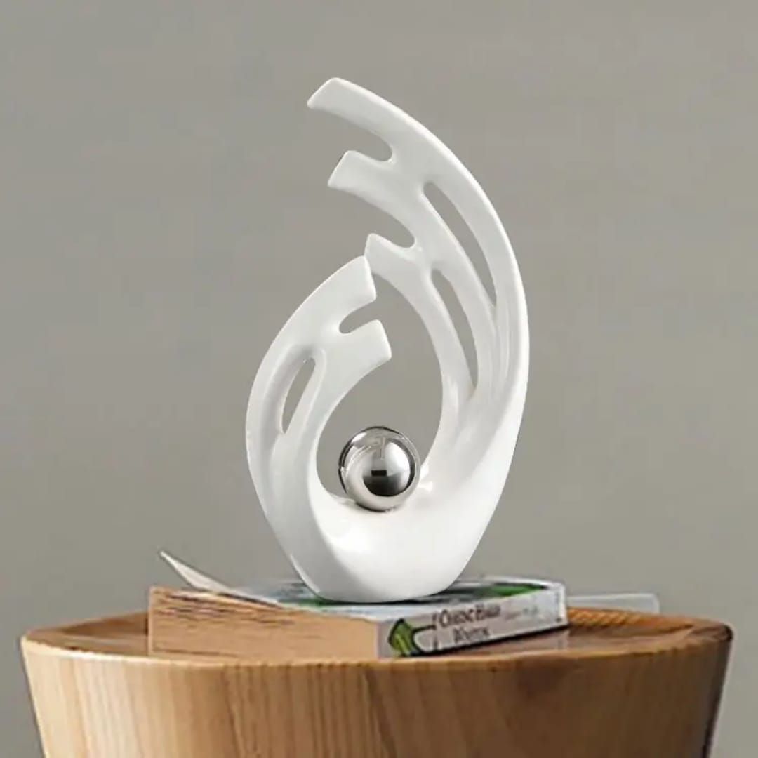 White abstract trophy with a silver ball centerpiece on a small wooden pedestal.