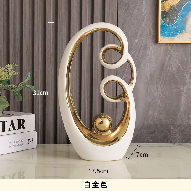 White and gold abstract tabletop sculpture with circular cutouts, shown with size labels on a gray background