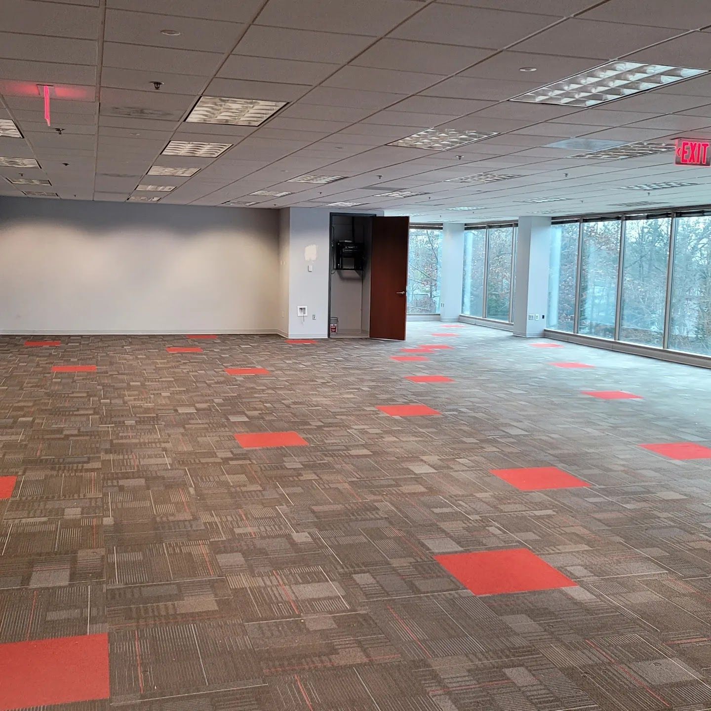 Empty office space with carpet and windows. Red squares are on the carpet.