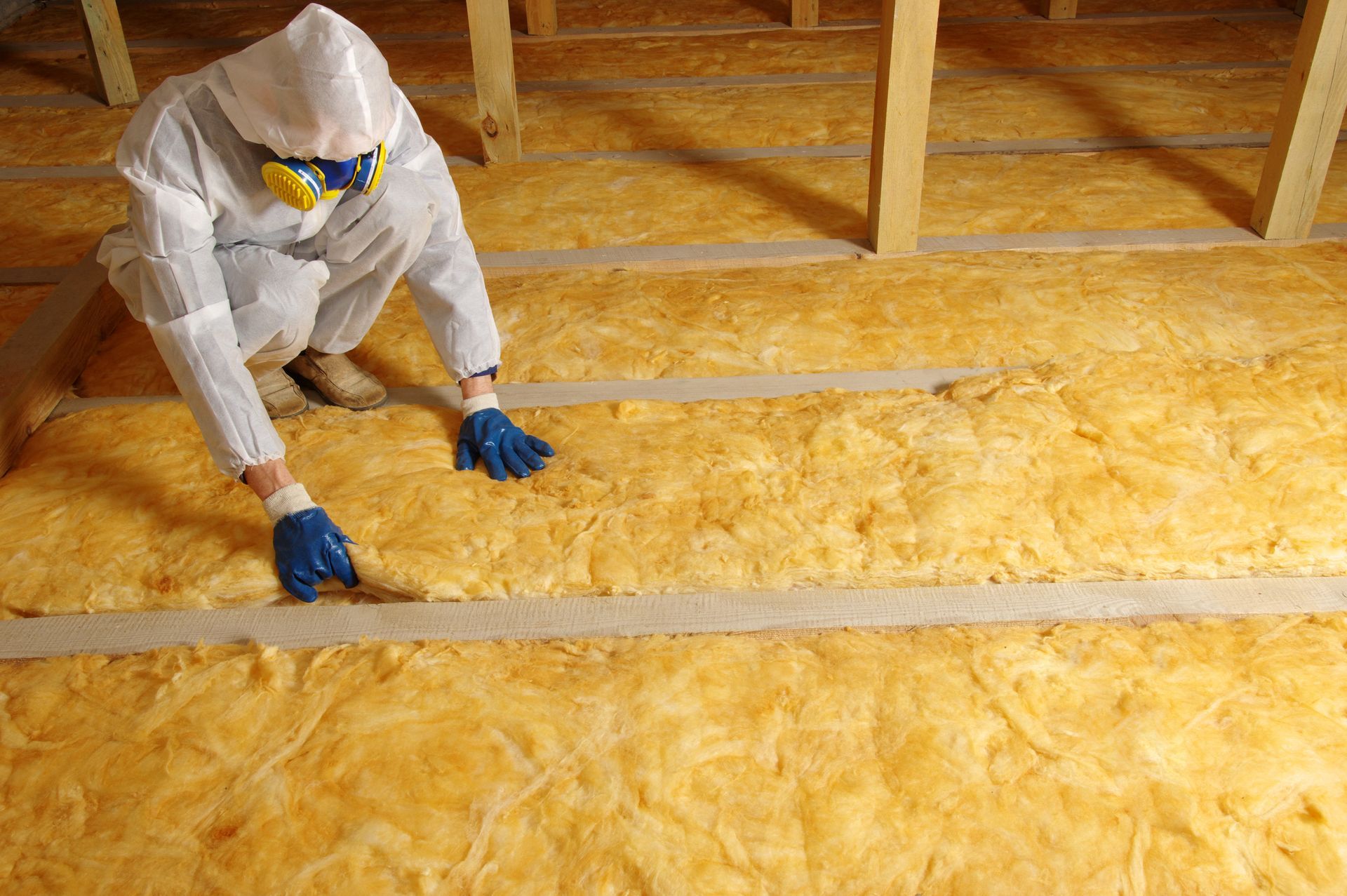 Person injecting insulation into a wall cavity with a hose. Person injecting insulation into a wall cavity with a hose.
