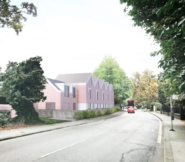 Quiet street with a pink building, trees, and a small red vehicle in the distance.