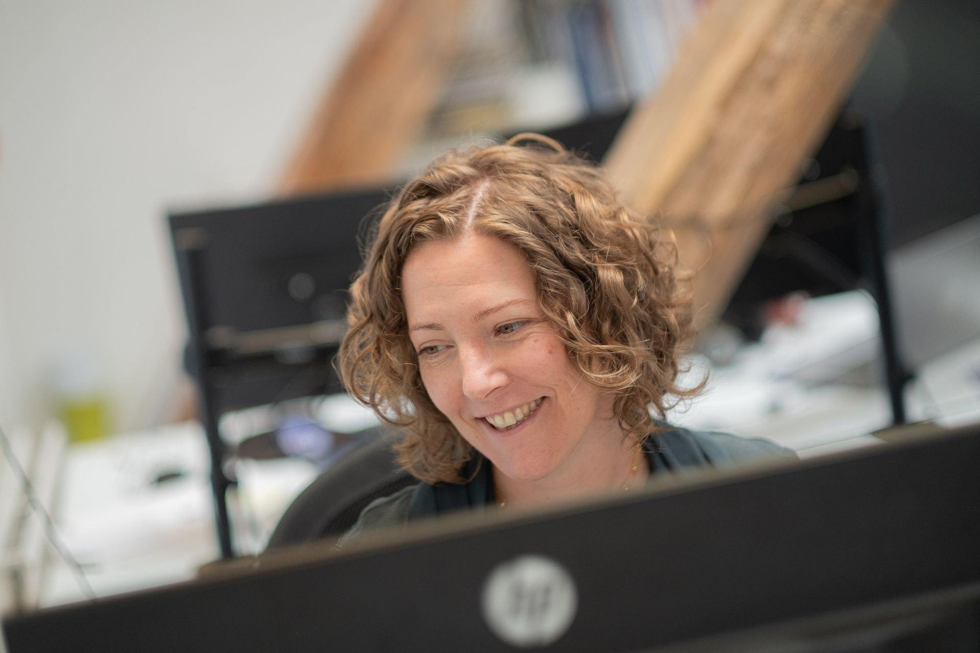 Smiling person working at a computer in an office setting