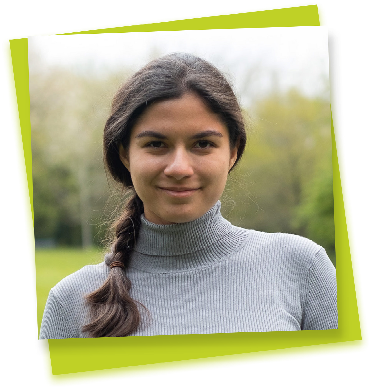 Portrait of a person with a braided hairstyle, wearing a gray turtleneck, against a blurred green outdoor background.