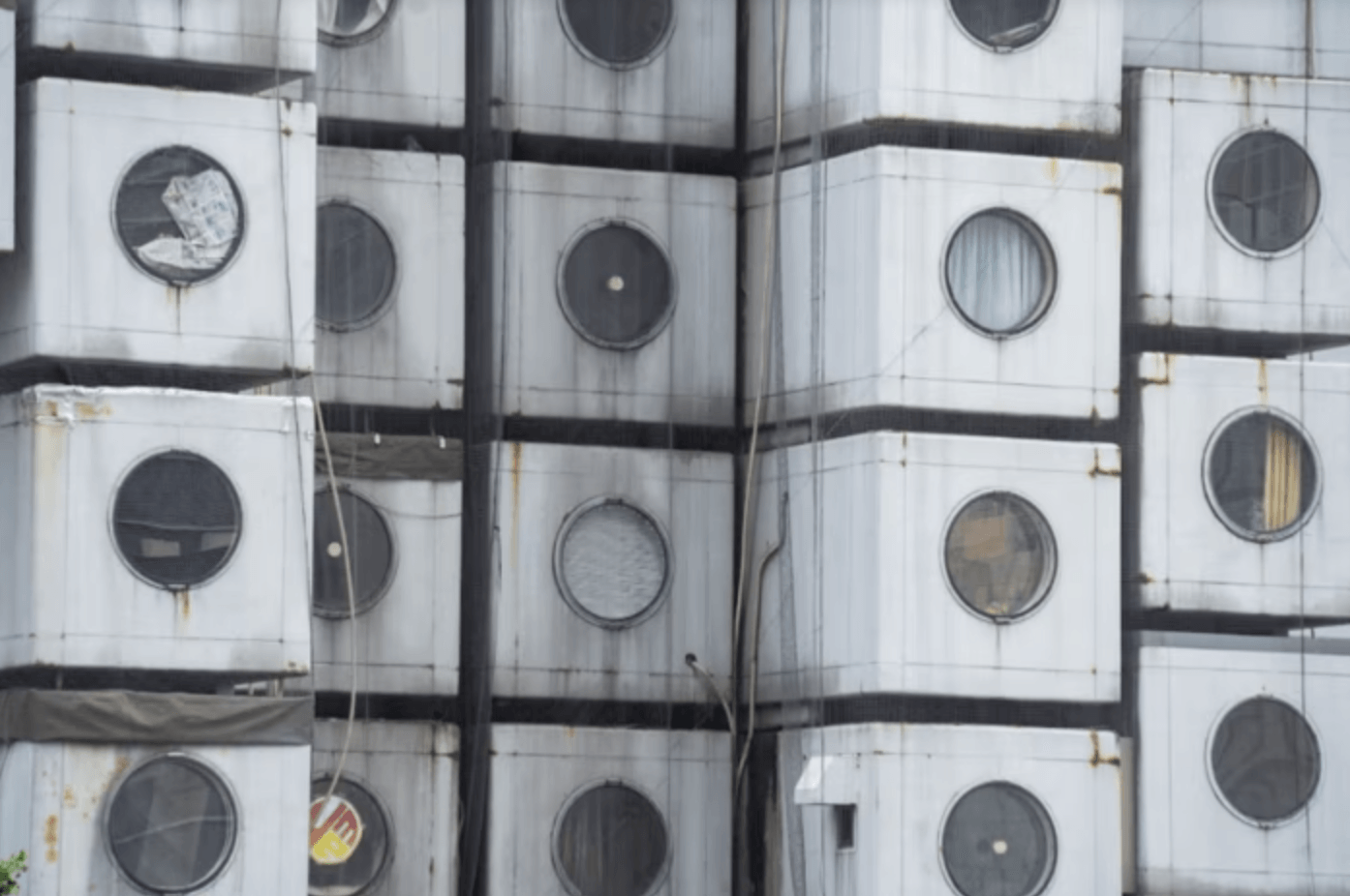 Stacked metal panels with circular windows in gray and white.