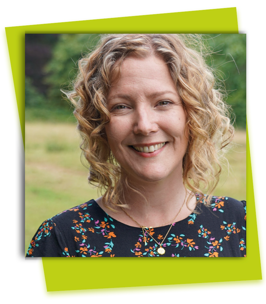 Smiling woman with curly blonde hair in a floral top against a blurred green background