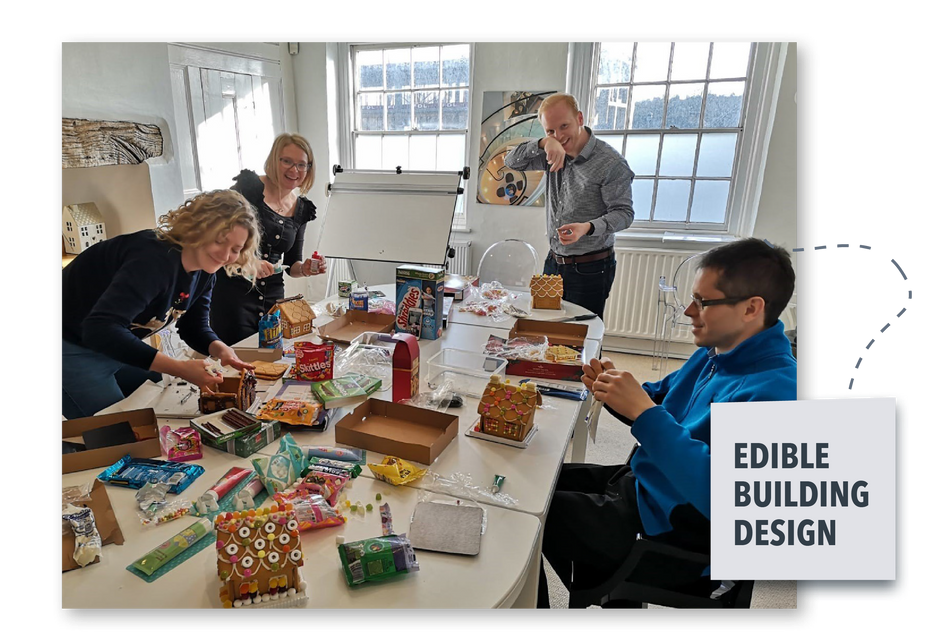 People designing edible building models at a table in a bright classroom or workshop