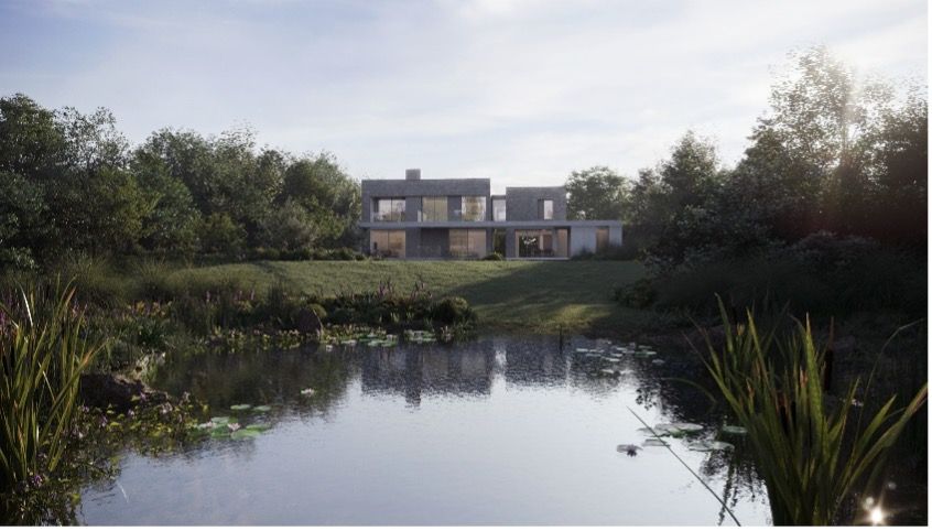 Modern house beside a calm pond, framed by trees and grasses at sunset