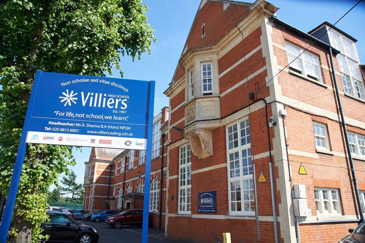 Blue Villiers sign outside a red-brick building on a sunny street
