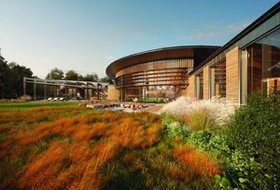 Modern building with curved wood facade beside a lush landscaped garden and walkway