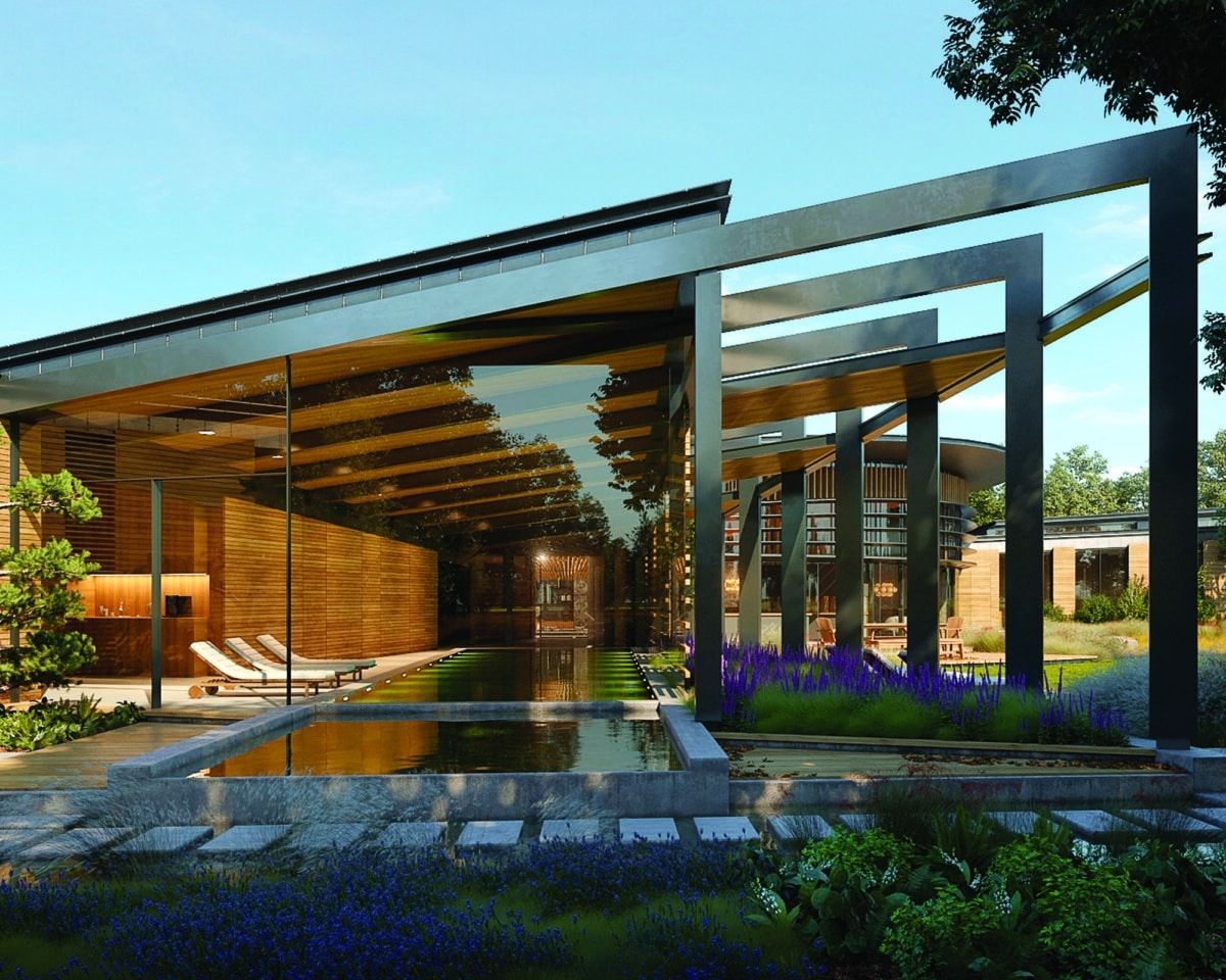Modern glass pavilion with warm wood interior, reflecting pool, and landscaped garden at sunset
