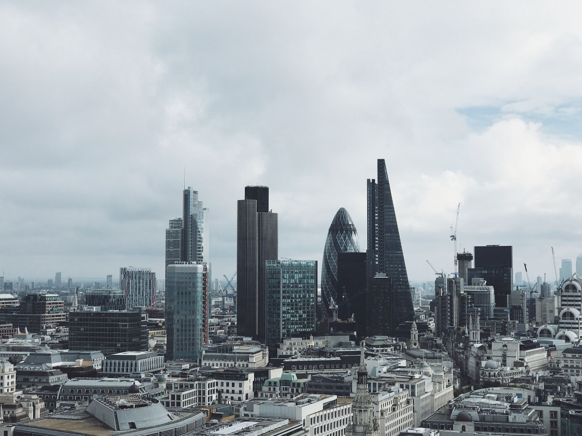 Modern city skyline with tall glass skyscrapers under a cloudy sky