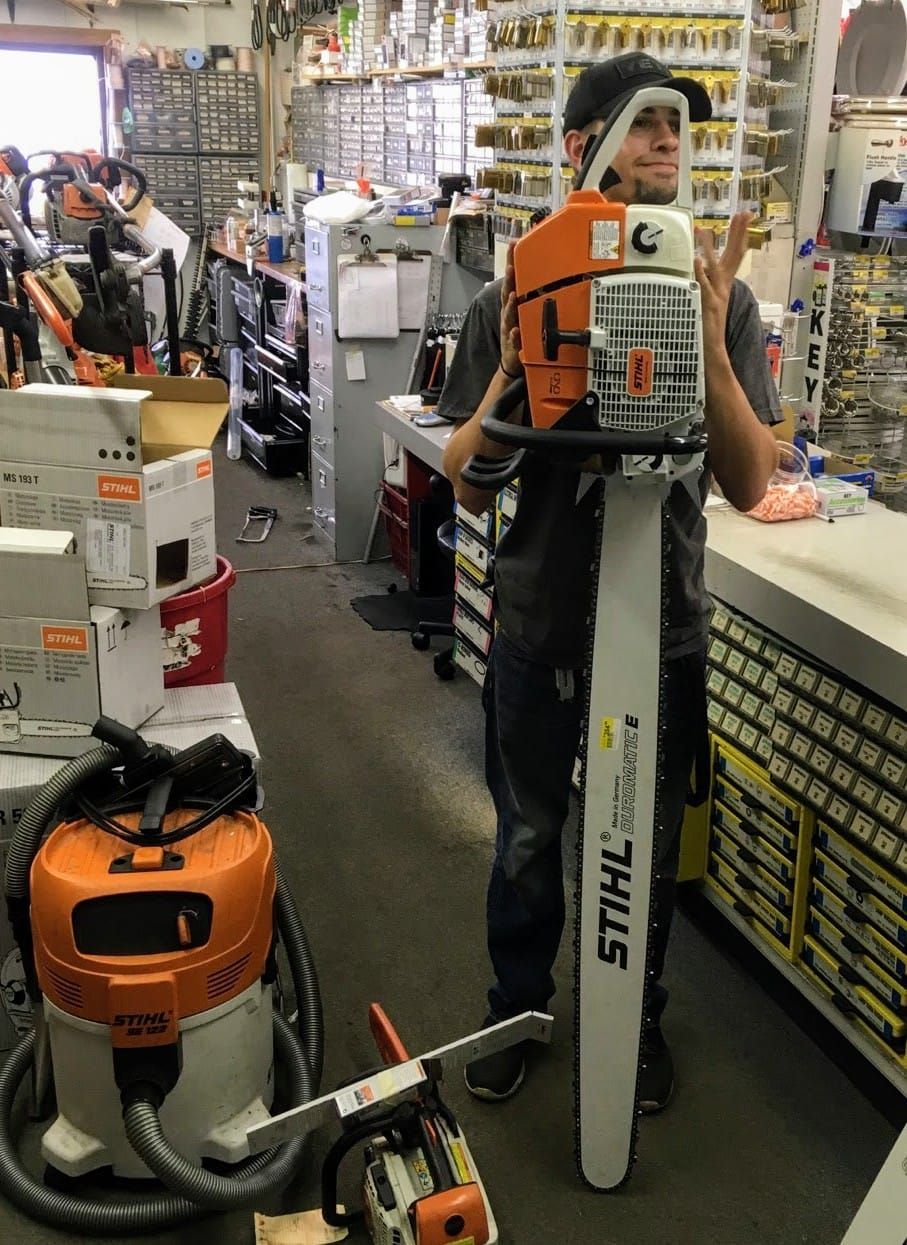 Person standing with a STIHL chainsaw display in a hardware store aisle