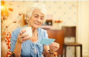 Happy Senior Holding Gift Card