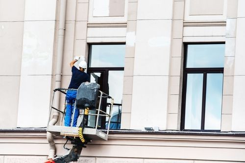A man painting around an office window