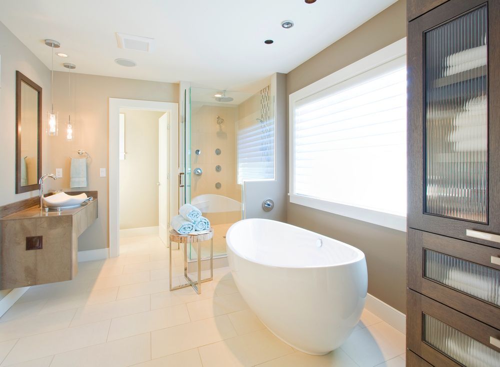 A painted bathroom with a large, white tub and brown walls