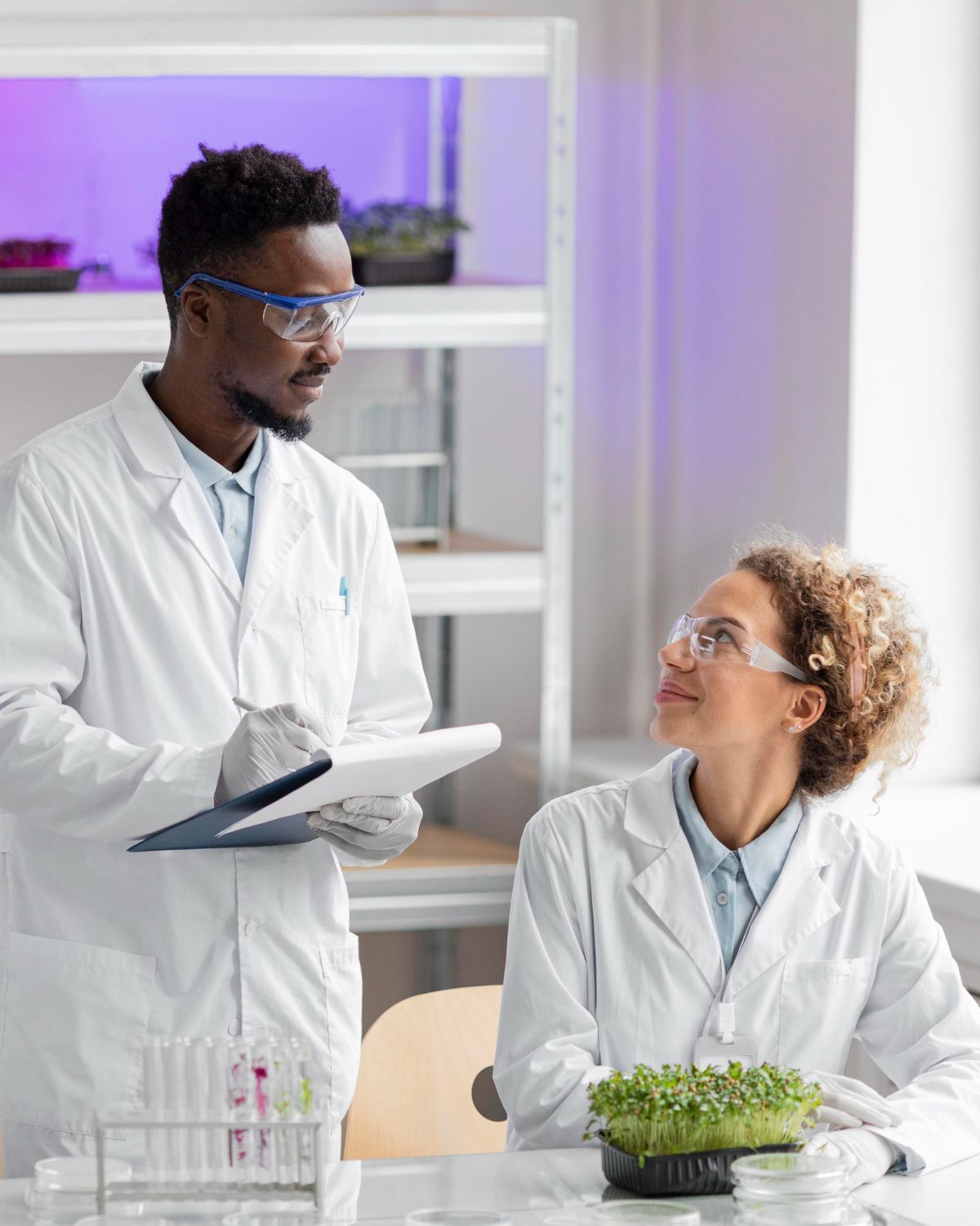 A man and a woman are standing next to each other in a lab.