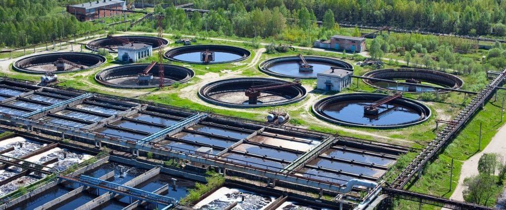 An aerial view of a large water treatment plant surrounded by trees.