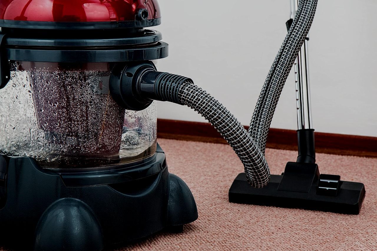 A vacuum cleaner is sitting on a carpet in a room.