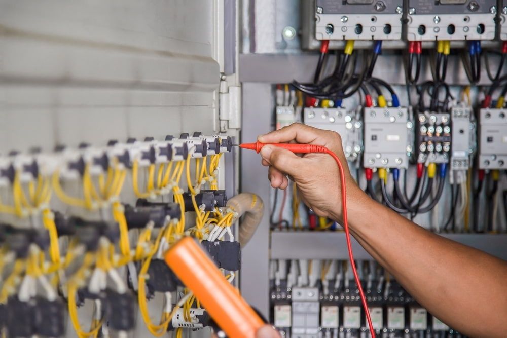 A Person is Using a Multimeter to Test a Circuit Board — Sigley Electrical in Mullumbimby, NSW