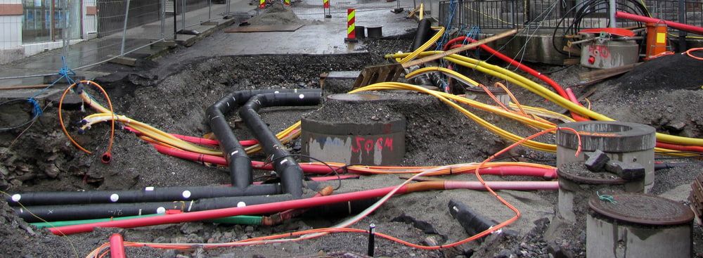 A Bunch of Electrical Wires Are Laying in the Dirt — Sigley Electrical in Byron Bay, NSW