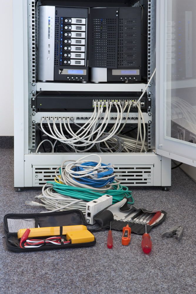 A Server Rack With a Lot of Wires and Tools on the Floor — Sigley Electrical in Wooli, NSW