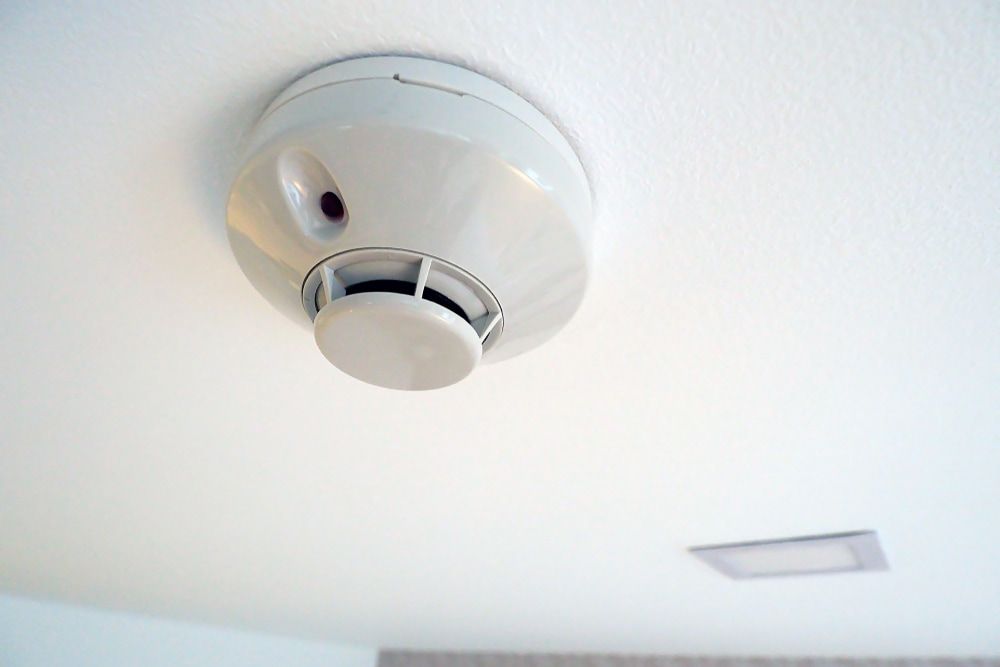 A Smoke Detector is Hanging From the Ceiling of a Room — Sigley Electrical in Brunswick Heads, NSW