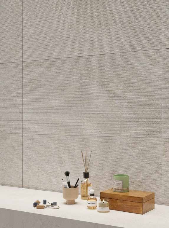 Bagno con pareti in colori neutri e un piano d'appoggio con articoli da toeletta, candele e oggetti decorativi.