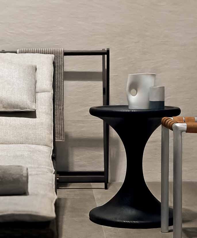 Parete del bagno con piastrelle testurizzate, bancone bianco, articoli da toeletta e scatola di legno.