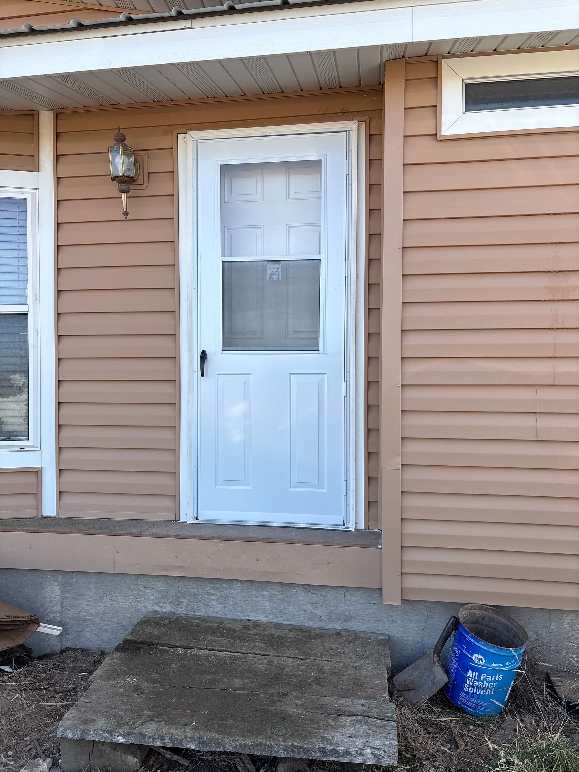 Person in blue cap measures kitchen cabinet with a tape measure.