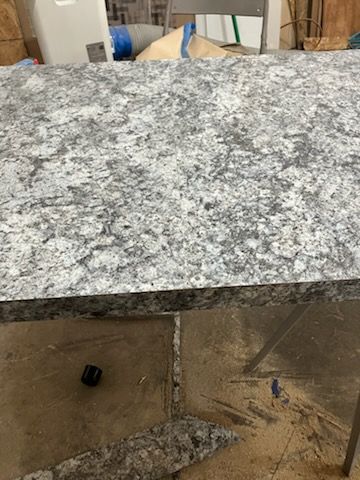 Granite countertop with a cutout underside, shown in a workshop or installation area