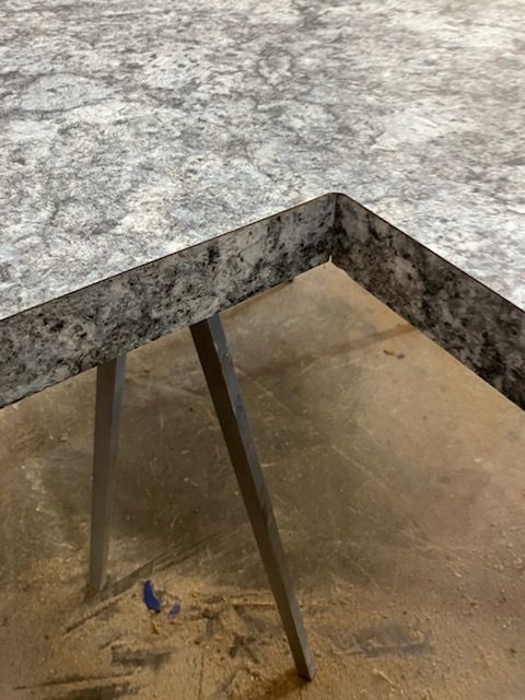 Gray stone tabletop with metal legs over a tan floor