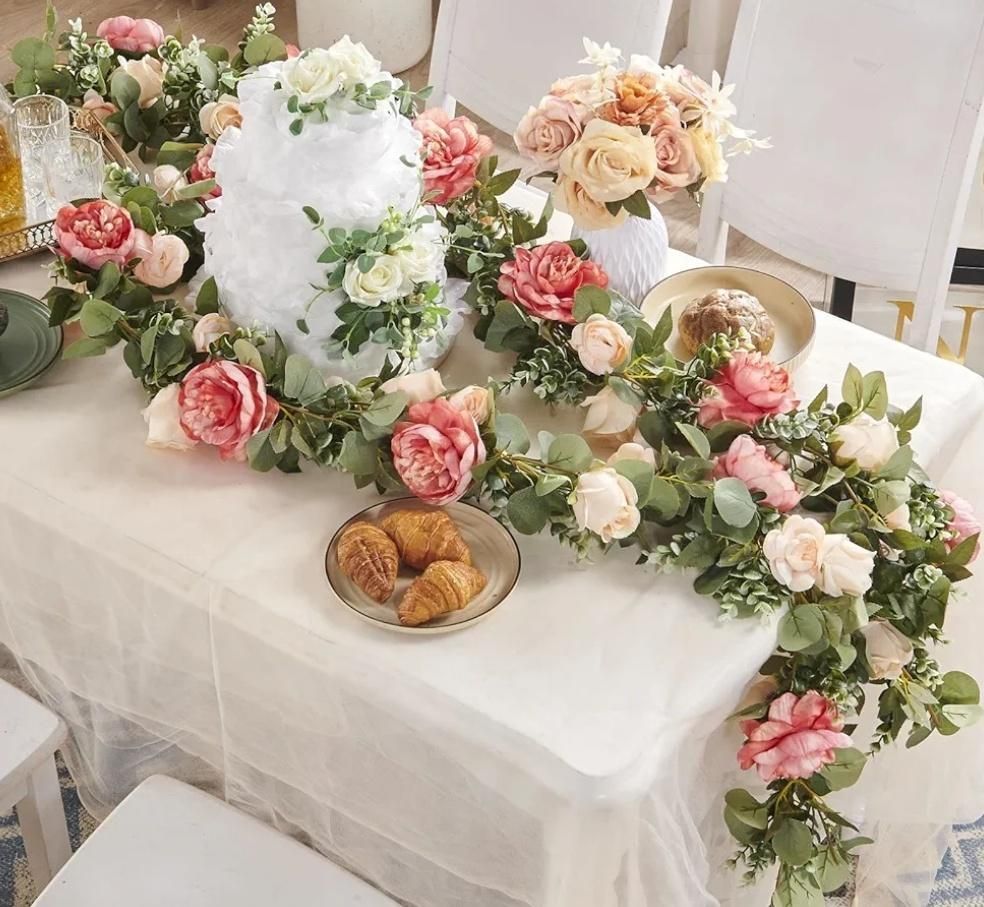 Table set for a celebration, decorated with flowers, cake, and pastries.